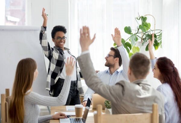 Happy business people group raise hands at corporate presentation training, participating in vote volunteering and questions at conference with coach leader