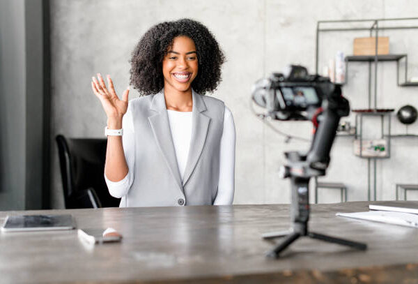 A businesswoman sitting at her desk in front of the camera implementing this YouTube AI Tools Masterclass in her own business