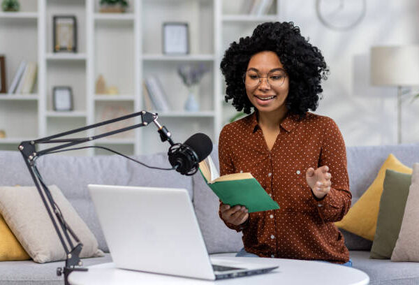 woman in front of a microphone and a laptop learning Audiobooks